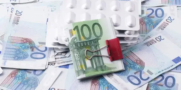 This image shows a stack of bills on top of medicine